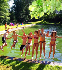 Badende springen gemeinsam in den Weiher